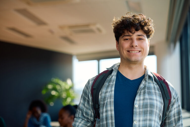 Happy student at university classroom looking at camera